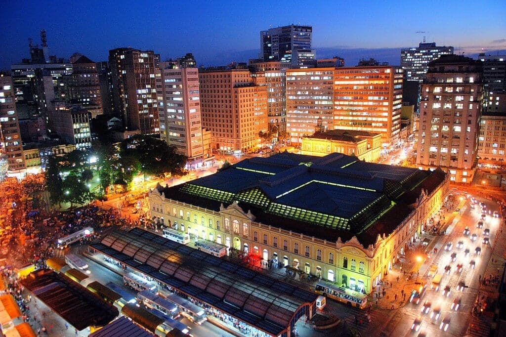 The Public Market lit up at dusk, seen from above amid the surrounding downtown buildings